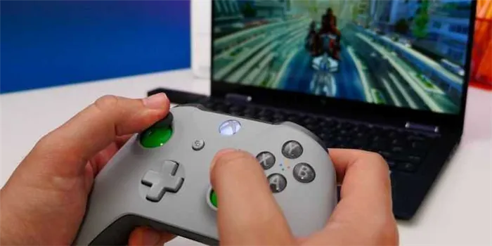Xbox One - человек, играющий в видеоигры с помощью контроллера Xbox на своем ПК